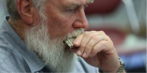 Closeup of a man playing harmonica