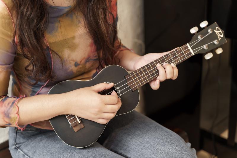 Closeup of a woman playing a ukulele