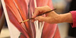Close up of a woman oil painting a flower