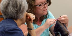Two women learning to knit