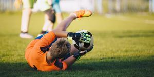 Action photo of boy catching a soccer ball