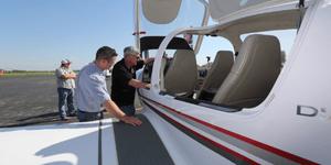 Two men checking out the cockpit of a small engine plane