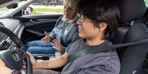 Young boy and driving instructor in a car learning to drive