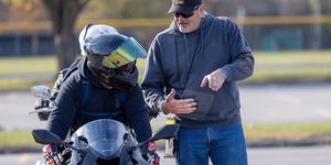 Male instructor guiding a male motorcycle rider
