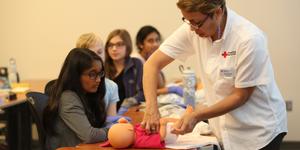 Redcross instructor showing a young girl diaper changing texchnique