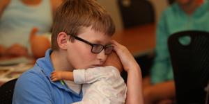 Young boy learning proper hold for an infant